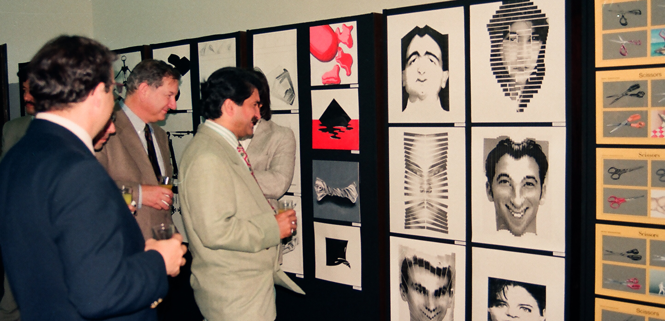 Gallery opening reception with framed works on the wall